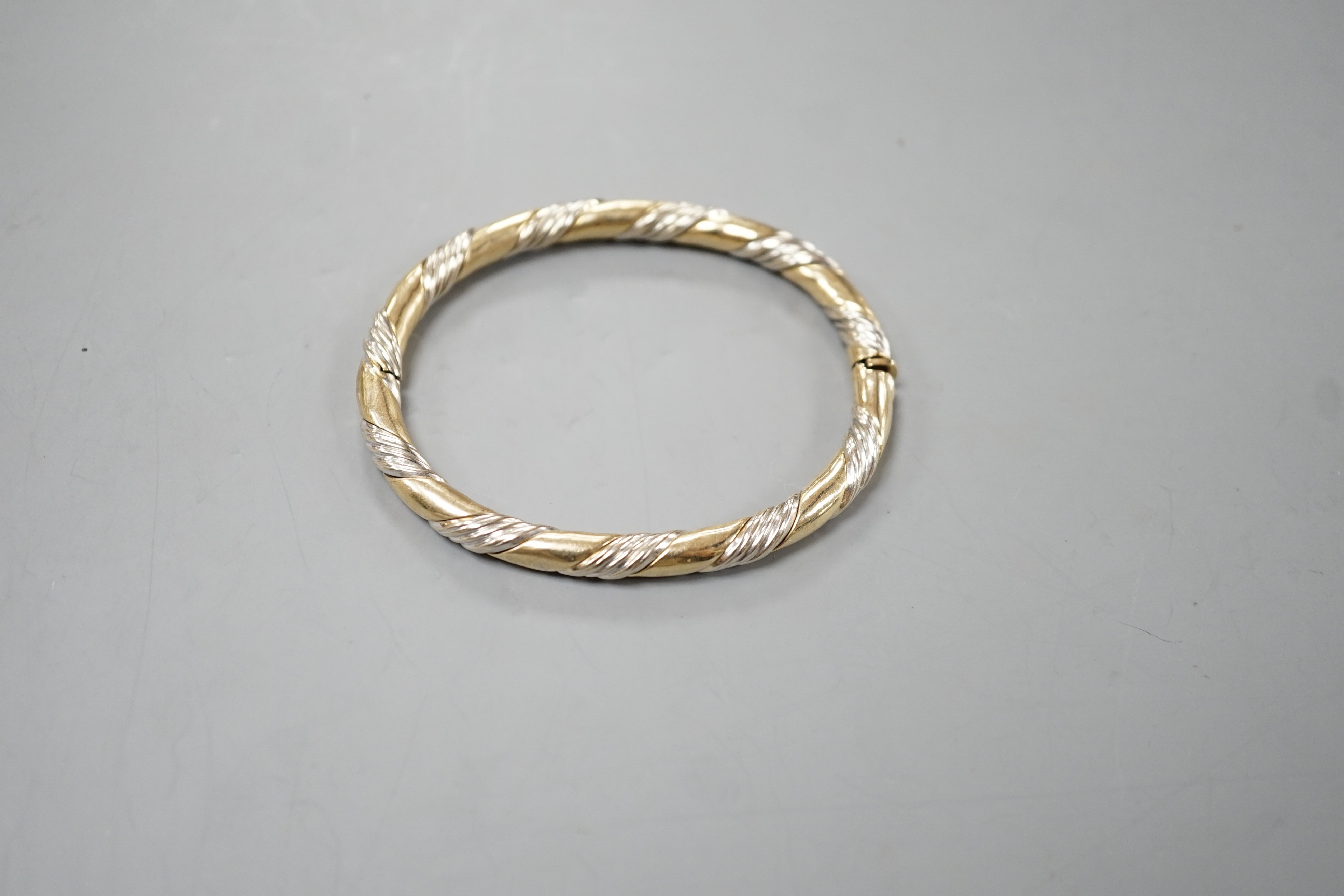 A modern two colour 9ct gold hinged bangle, interior diameter 58mm, 18.7 grams.